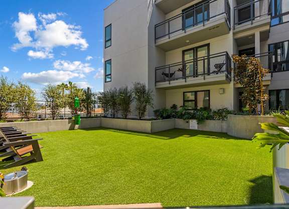 Courtyard green space with lounge chairs and planters at AMP 30 Apartments, California