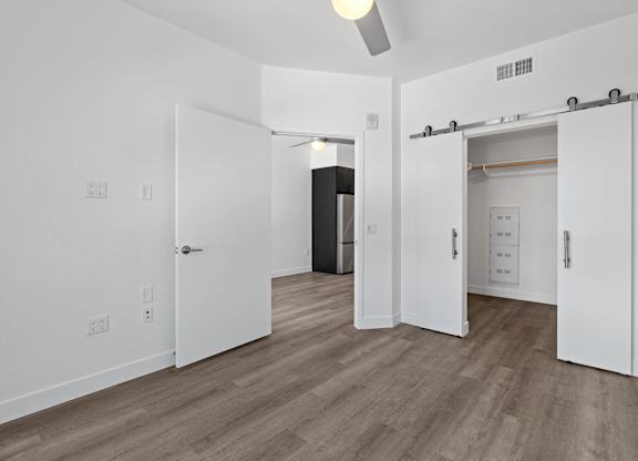 Spacious bedroom with walk-in closet and barn doors at AMP 30 Apartments, California, 92116