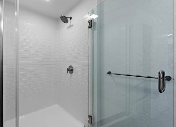 Walk-in shower with white subway tile and glass door at AMP 30 Apartments, San Diego, CA 92116