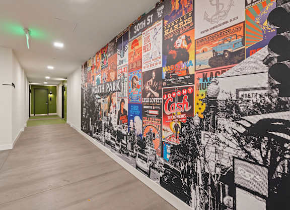 Hallway with vintage music poster collage wall at AMP 30 Apartments, San Diego, 92116