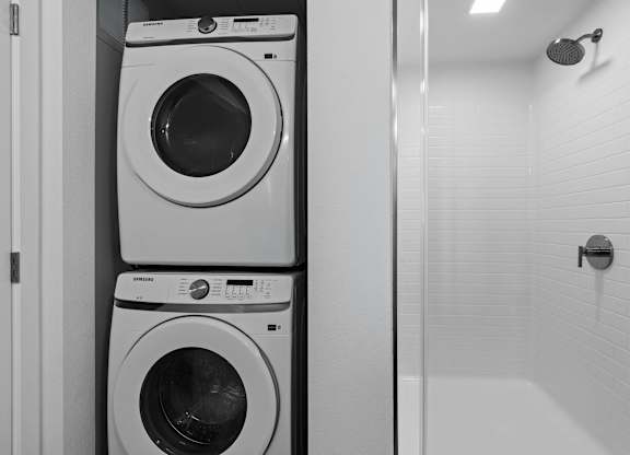 Stacked washer and dryer with walk-in shower at AMP 30 Apartments, San Diego