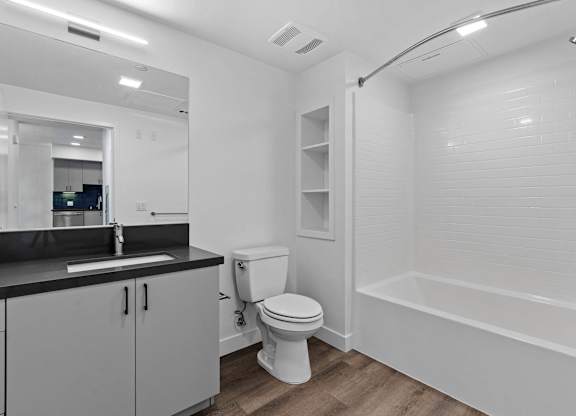 Bathroom with black countertop and white subway tile at AMP 30 Apartments, California, 92116