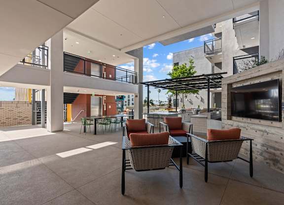 Outdoor lounge with pergola and mounted television at AMP 30 Apartments, San Diego, California