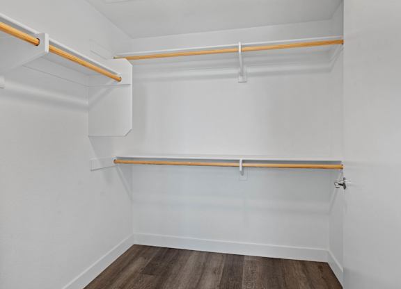 Walk-in closet with wooden hanging rods and shelving at AMP 30 Apartments, California, 92116
