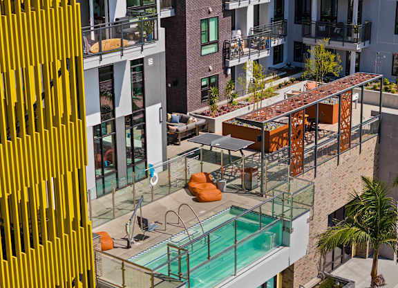 Elevated pool deck with pergola and rooftop garden at AMP 30 Apartments, San Diego, California