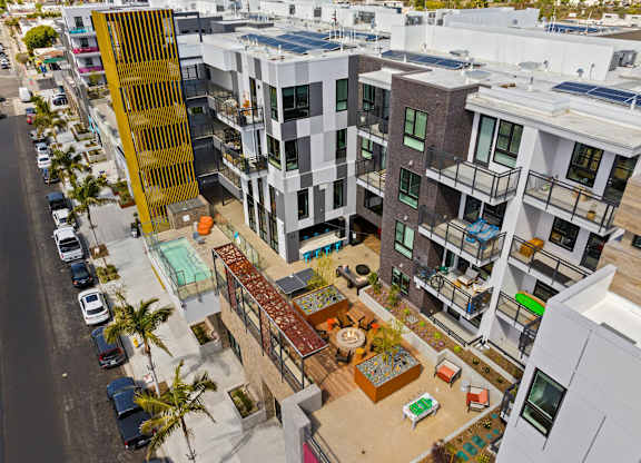 Aerial view of courtyard with fire pit and seating at AMP 30 Apartments, San Diego