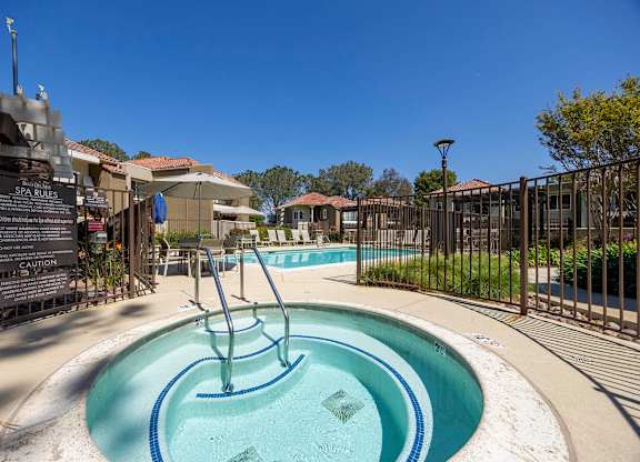 A pool with a slide and a sign that says spa rules.