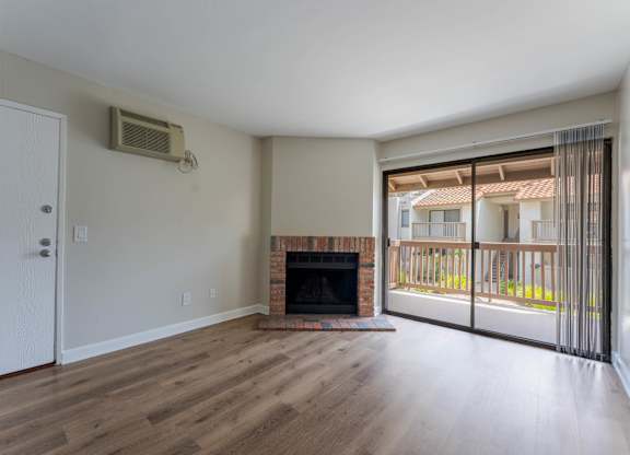 A room with a fireplace and sliding glass doors.