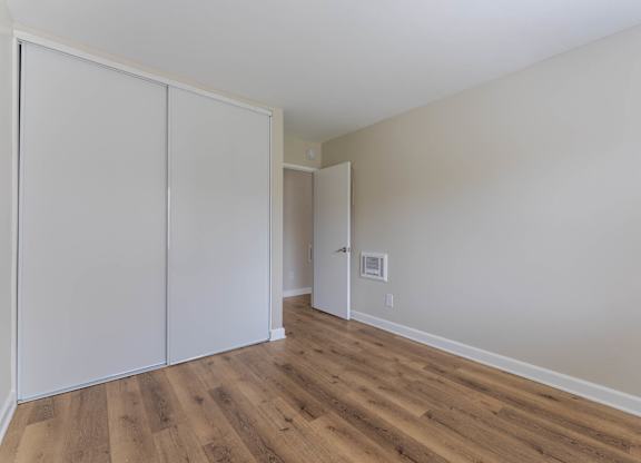 A room with a white wall and a white closet door.