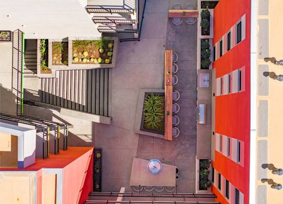 A patio with a table and chairs is surrounded by orange and white walls.