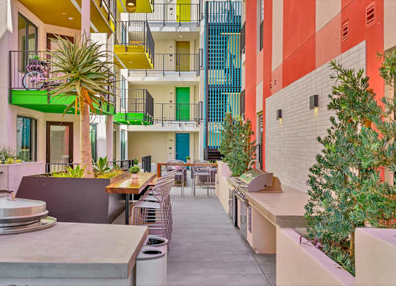 A patio with a table and chairs is surrounded by colorful buildings.