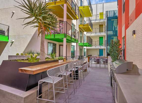 A patio with a table and chairs is surrounded by buildings.