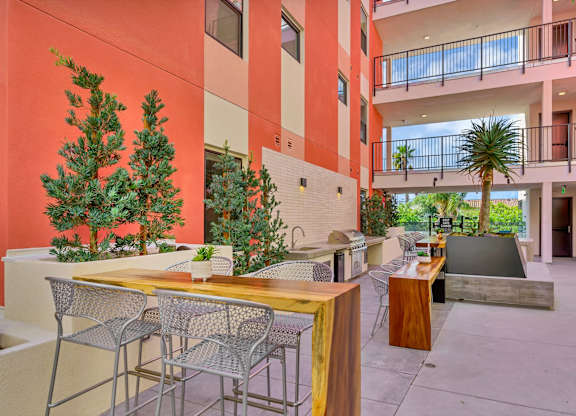 A patio with a table and chairs is surrounded by a red wall.