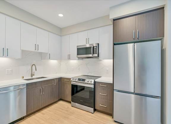 A modern kitchen with stainless steel appliances and wooden cabinets.