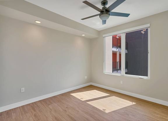 A room with a ceiling fan and a window.
