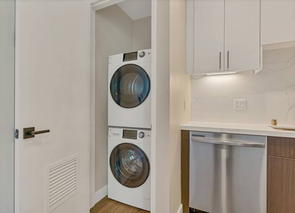A white front-loading washing machine is in a laundry room.