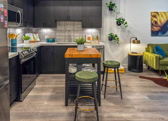Open concept kitchen with island seating and living area at AMP 30 Apartments, San Diego, CA 92116