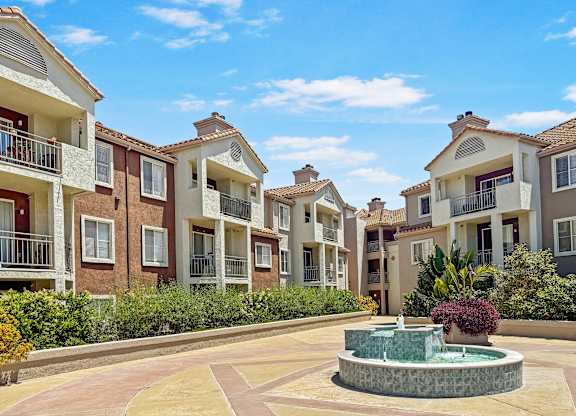 A courtyard with a fountain surrounded by apartment buildings.