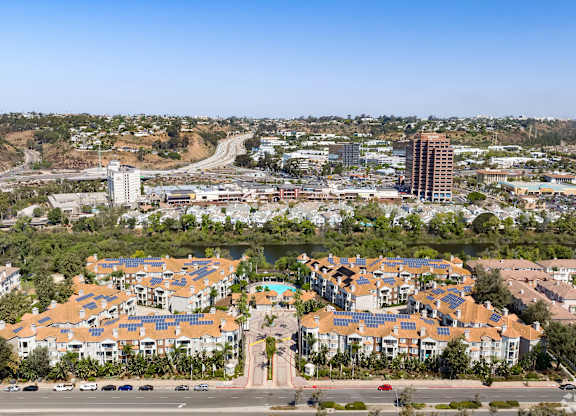 A large housing development with apartment buildings and solar panels on the roofs.