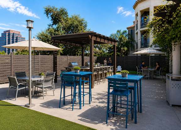A blue table and chairs are set up on a patio.