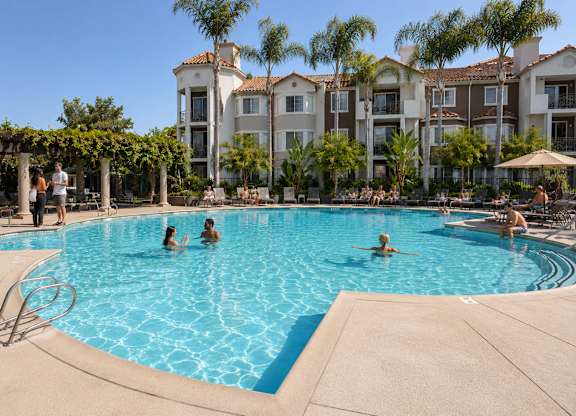 A group of people are enjoying the pool at a resort.