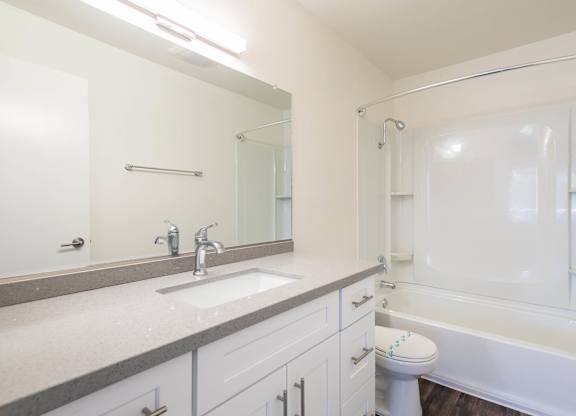 A white bathroom with a sink, toilet, and bathtub.