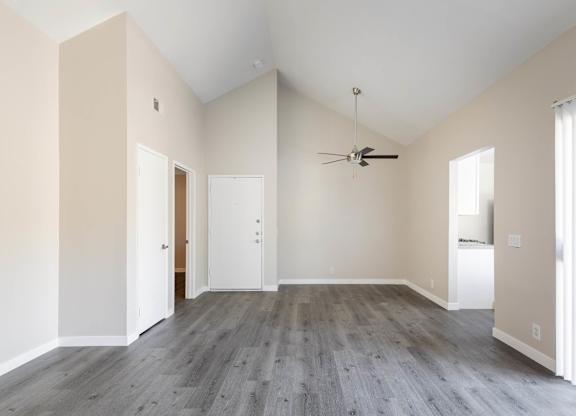 A room with a ceiling fan and a window with blinds.