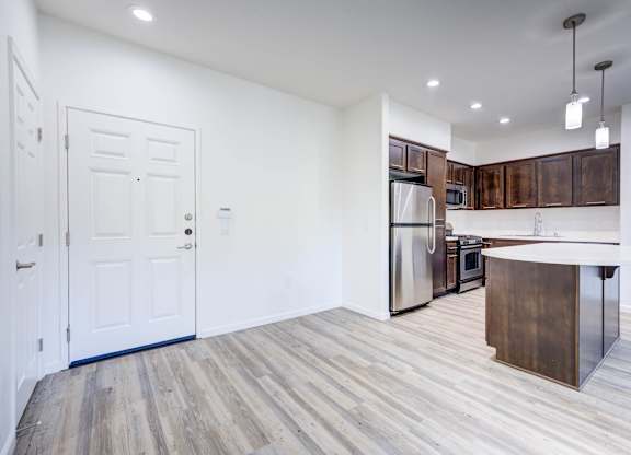 A kitchen with a white door and a white fridge.