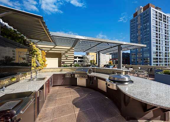 A rooftop patio with a bar and a view of the city.