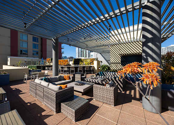 A patio with a white canopy and grey furniture.