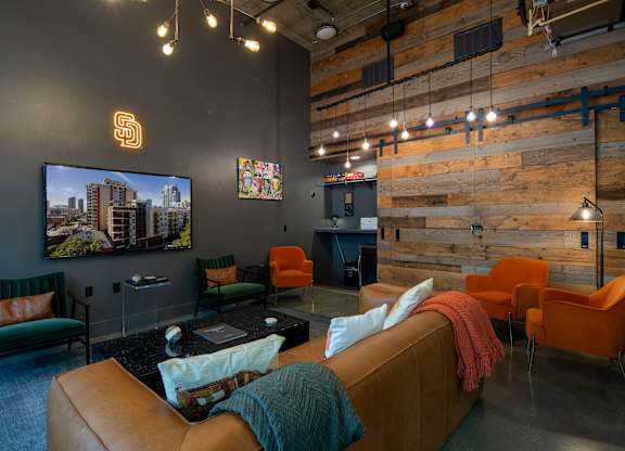 A living room with a couch, chairs, and a television.