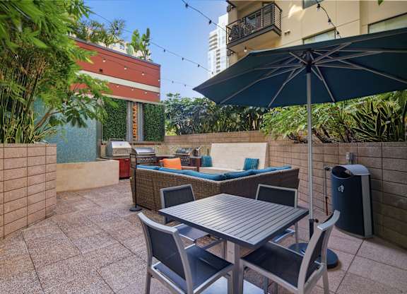 A patio with a table and chairs under an umbrella.