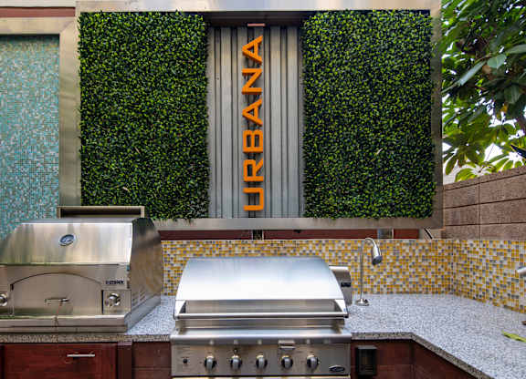 A grill is on a counter in front of a green wall.