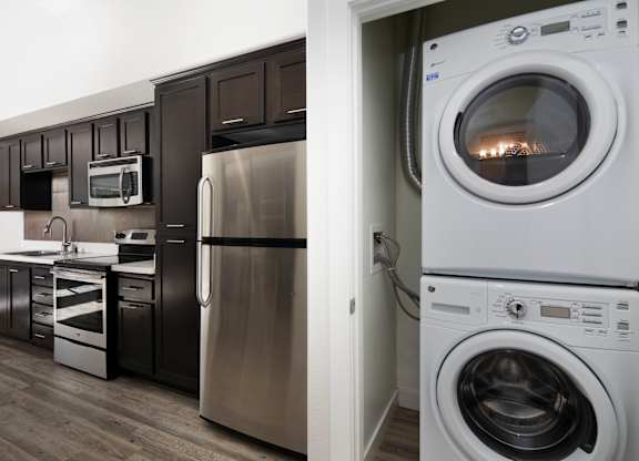 A modern kitchen with a stainless steel refrigerator and a white washing machine.