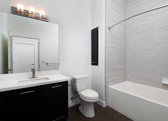 A white toilet sits next to a white sink in a bathroom.