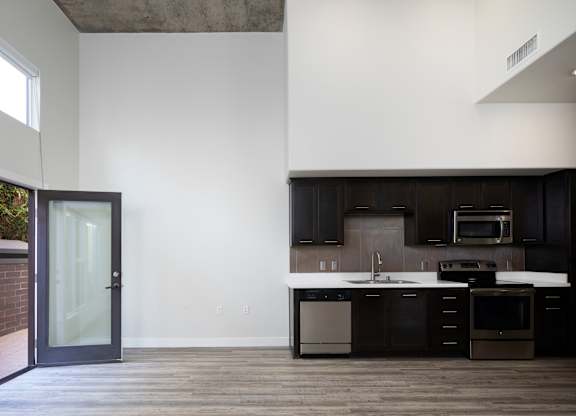A modern kitchen with dark brown cabinets and a white countertop.