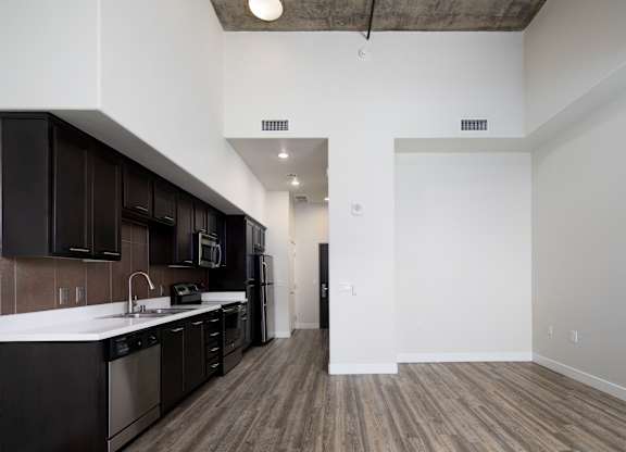 A kitchen with black cabinets and a white countertop.