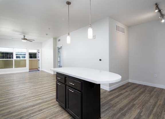 A kitchen with a white counter and black cabinets.