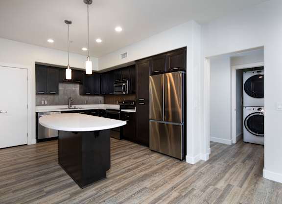 A modern kitchen with dark wood cabinets and stainless steel appliances.
