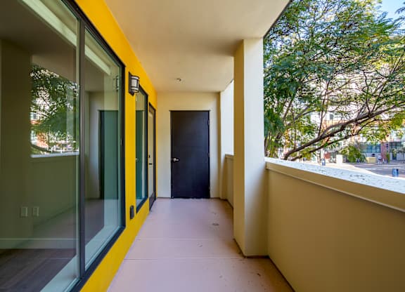 A hallway with a yellow stripe and a black door.