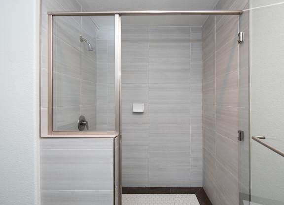 A white bathroom with a walk in shower.