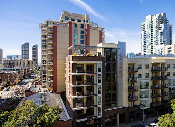 Apartment buildings are shown in the foreground with a city skyline in the background.