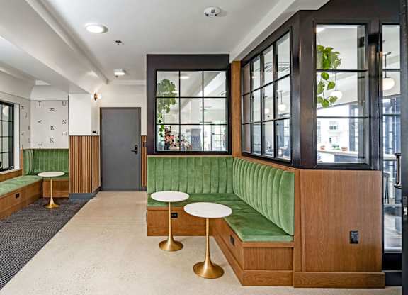 A room with a green couch and a wooden door.