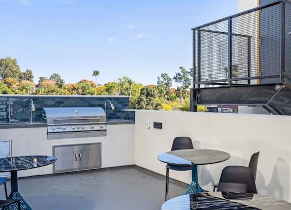 A patio with a table and chairs overlooking a backyard.