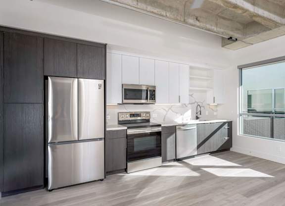 A modern kitchen with a stainless steel refrigerator and microwave.