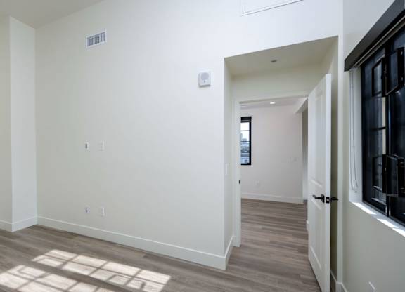 A room with a white wall and a door on the right.
