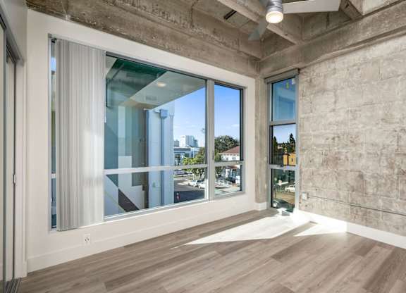 A room with a large window and a wooden floor.