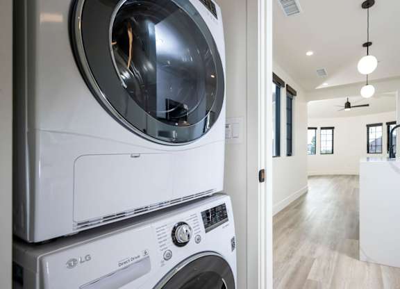 A white LG washing machine and dryer in a modern laundry room.