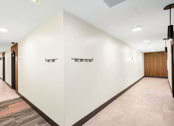 A long hallway with a sign that says "EXIT" on the wall.