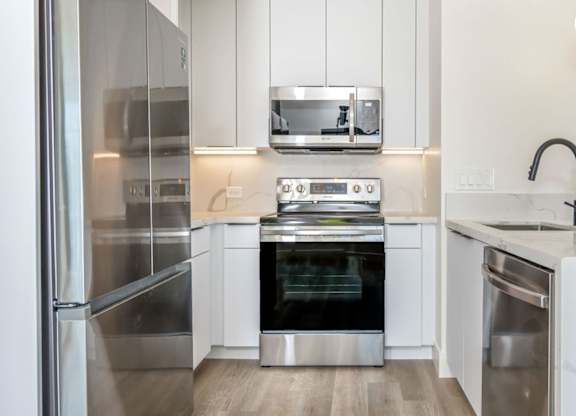 A modern kitchen with stainless steel appliances and white cabinets.